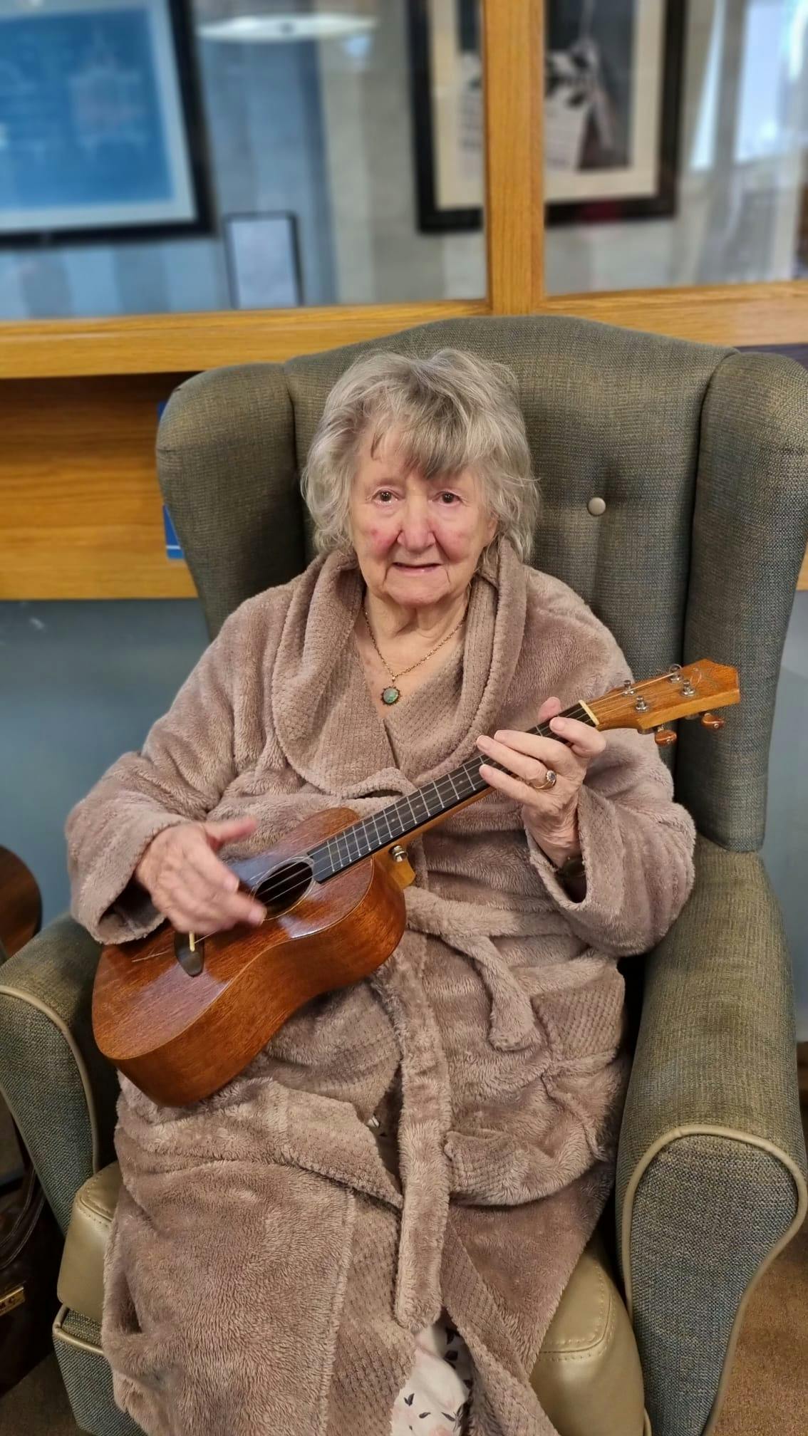 A resident playing a small guitar