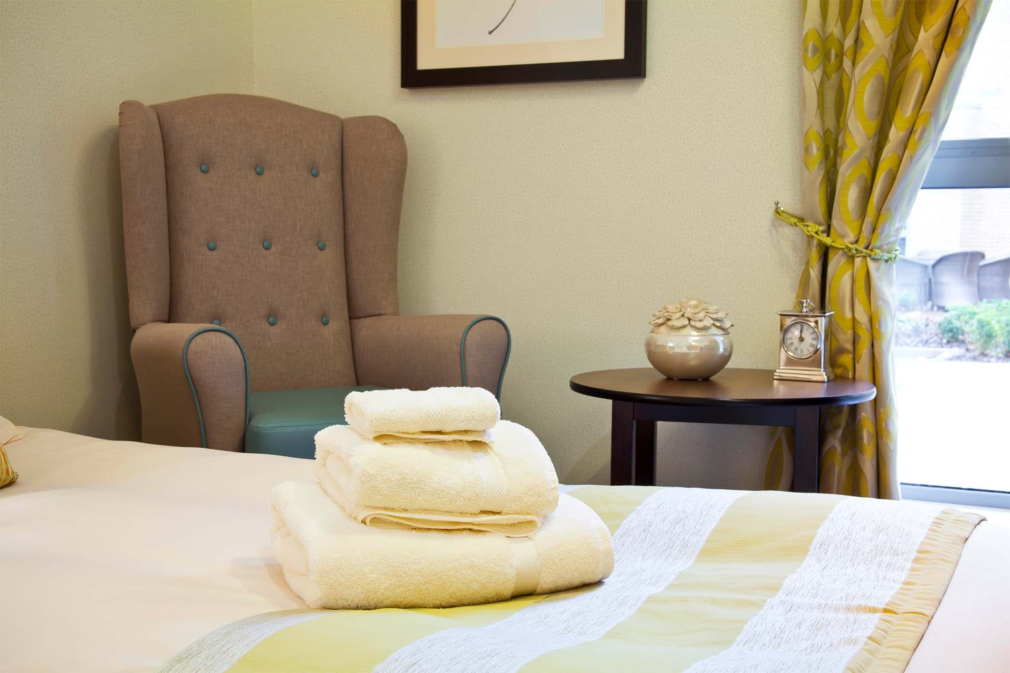 Yellow towels stacked on a bed