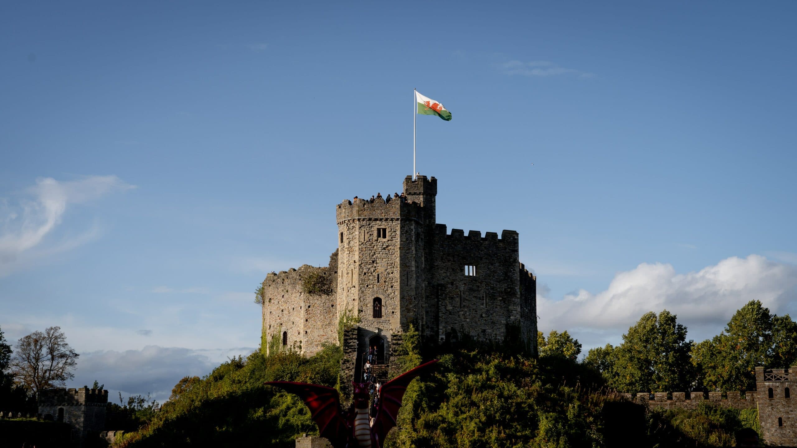 A shot from far of a Castle in Cardiff on a sunny day with a few clouds.