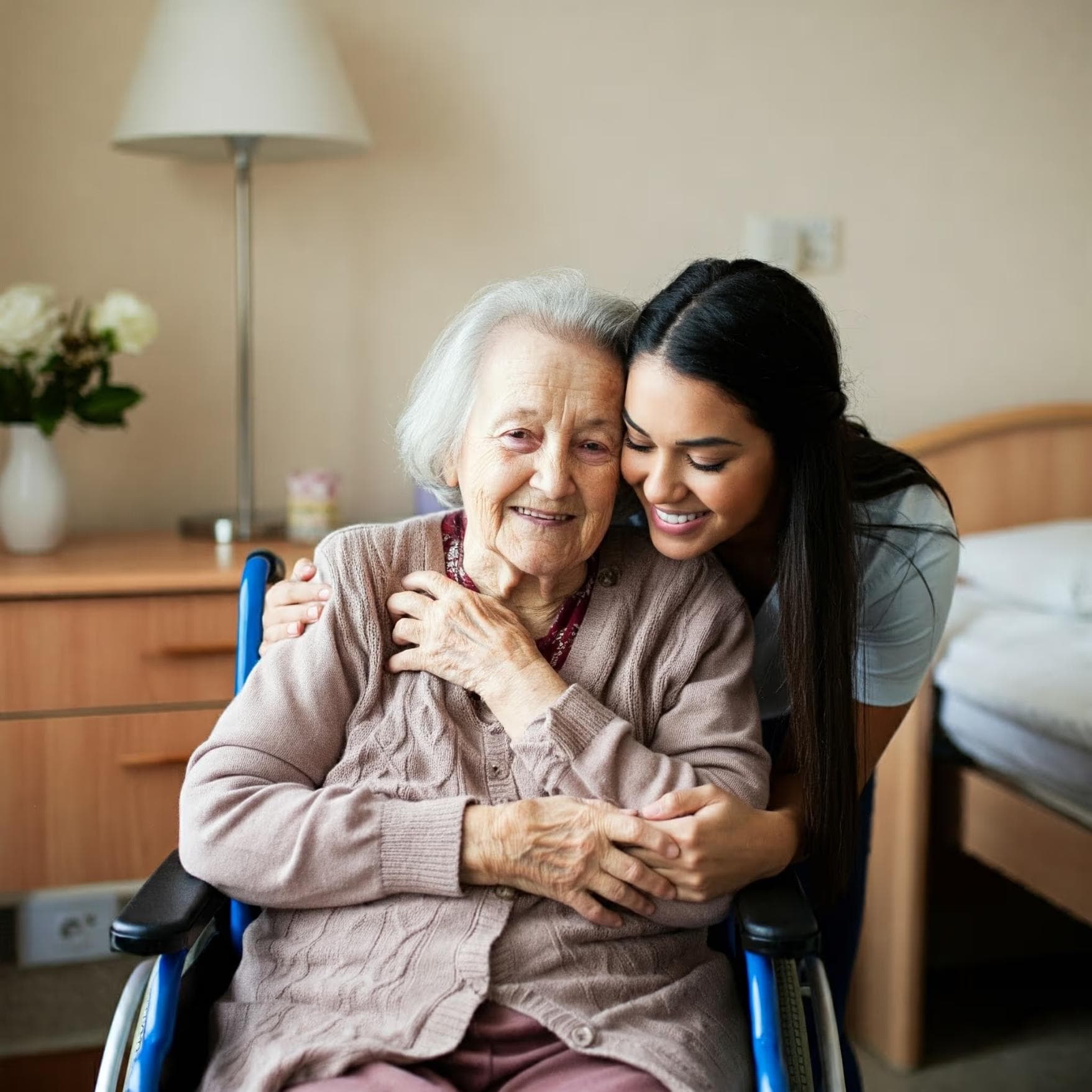 Resident sat in wheelchair hugging carer