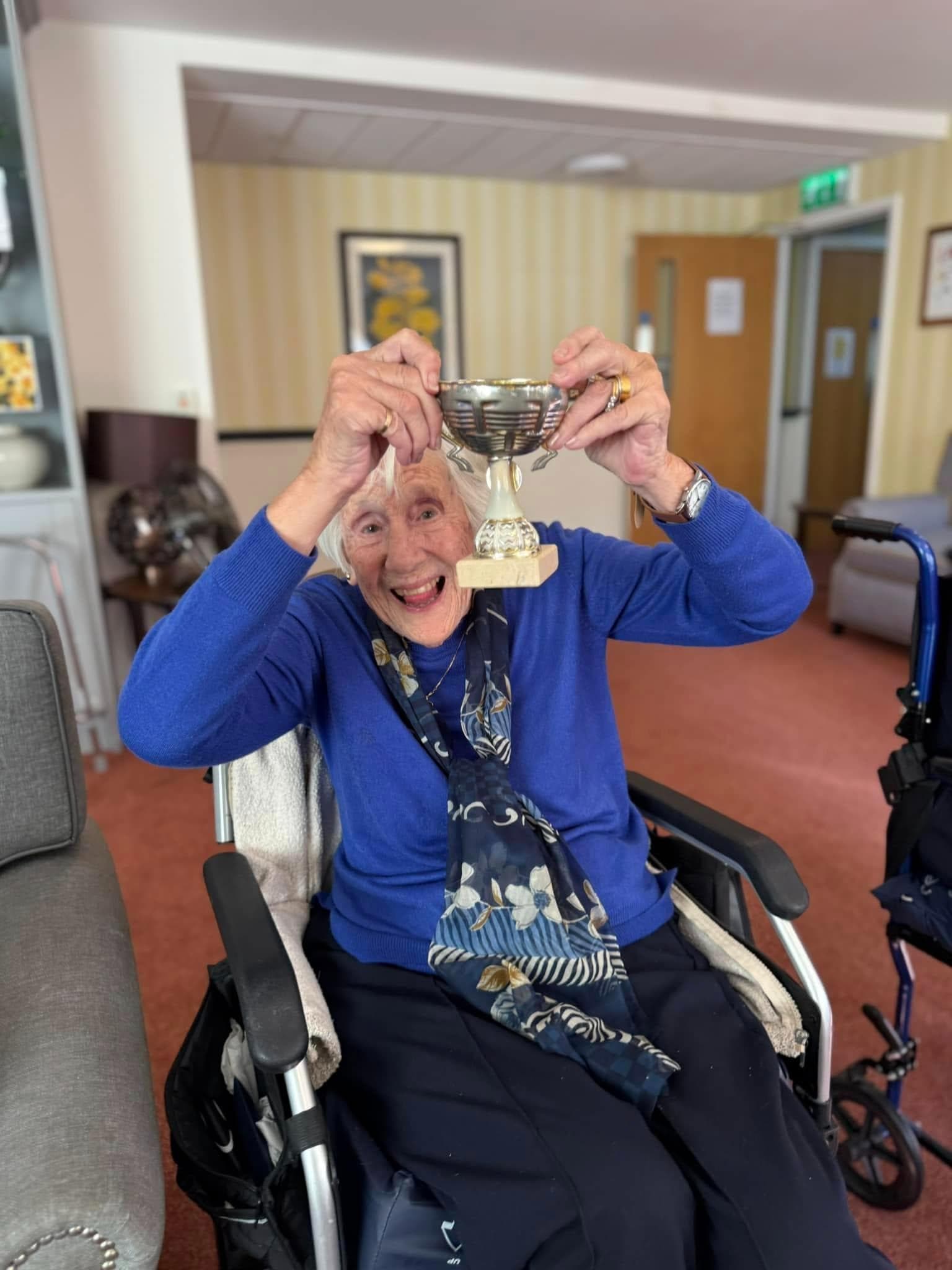 one of our residents holding up a trophy