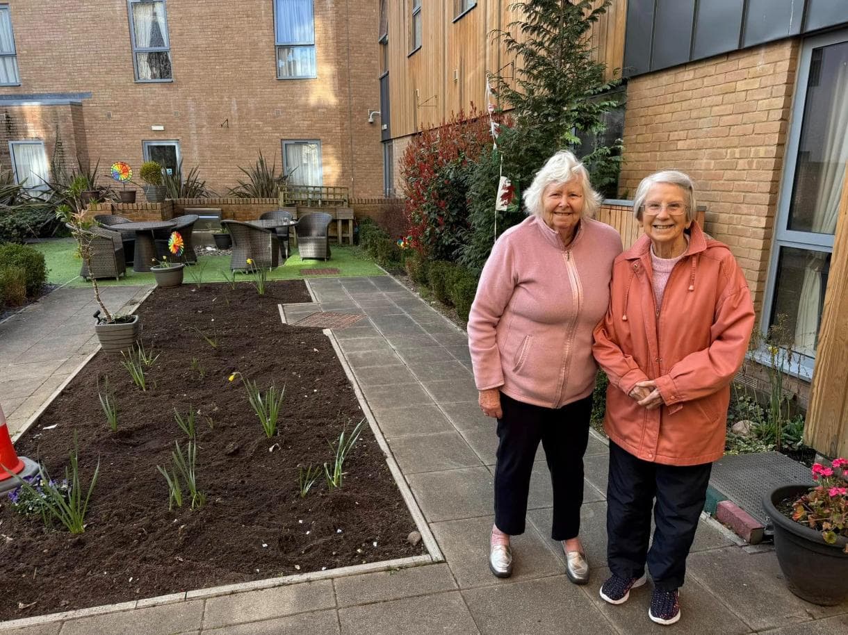 two of our residents in the garden smiling