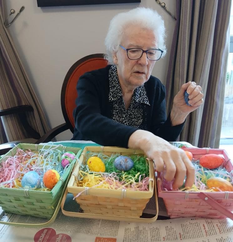 older lady wearing glasses looking at easter baskets