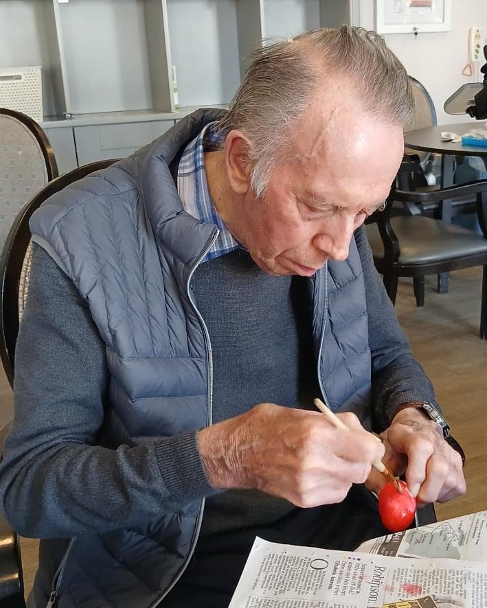 older man painting an egg