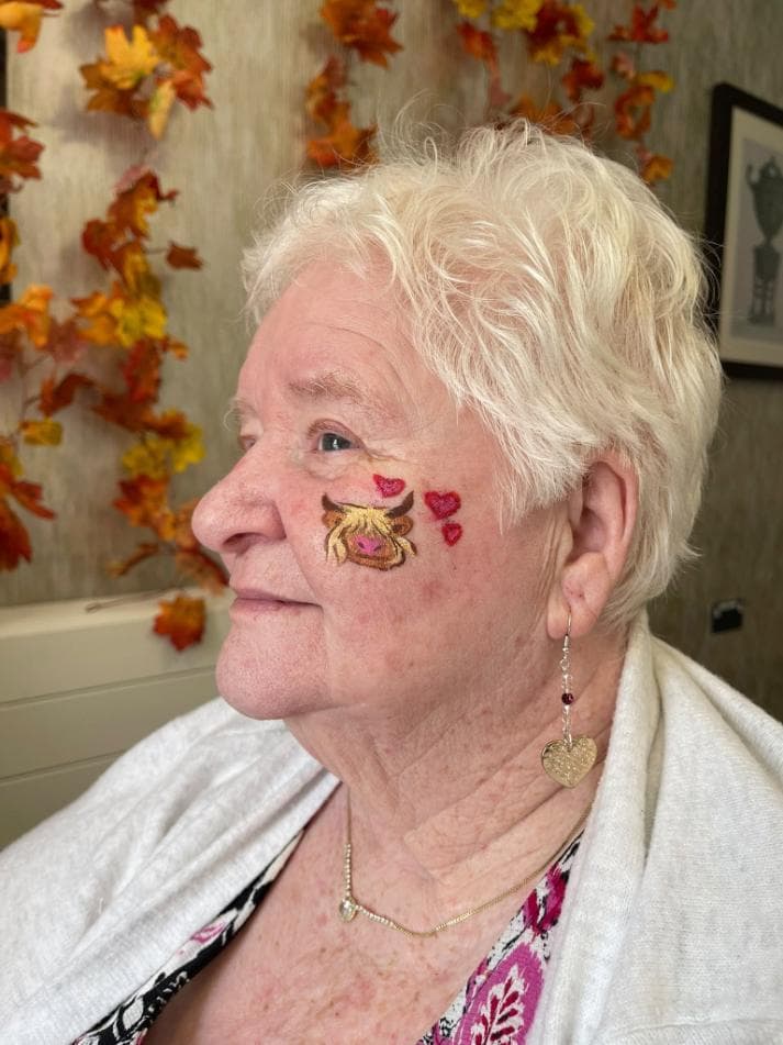 older lady with some face paint on here cheek
