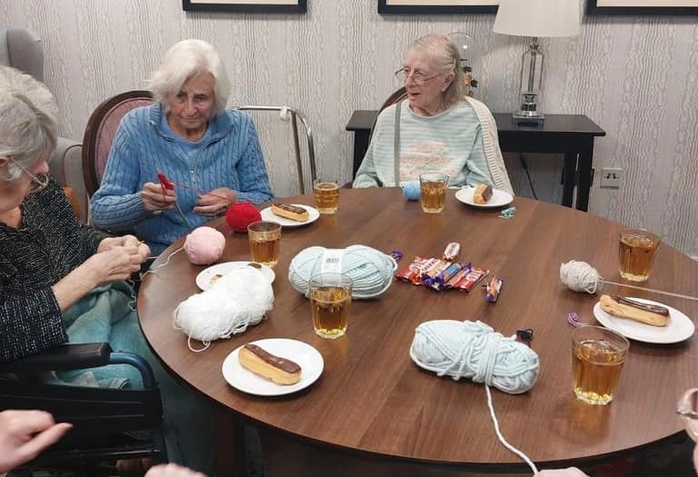 Our residents knitting blankets for a dog home at Ty Llandaff Care Home