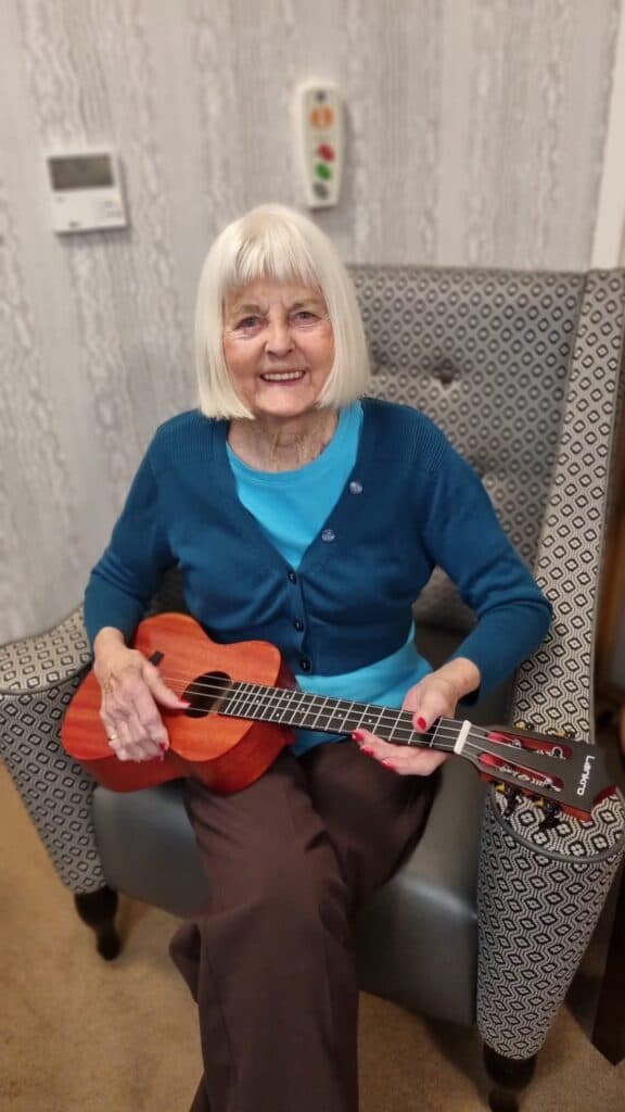 A resident playing a small guitar