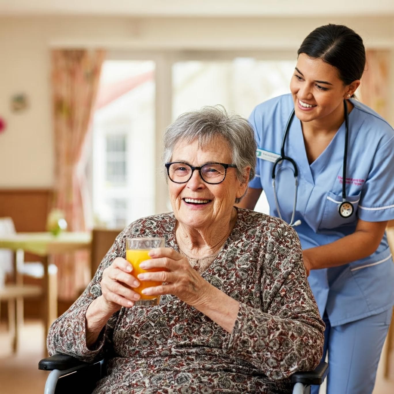 A resident with glass of orange juice being helped by carer