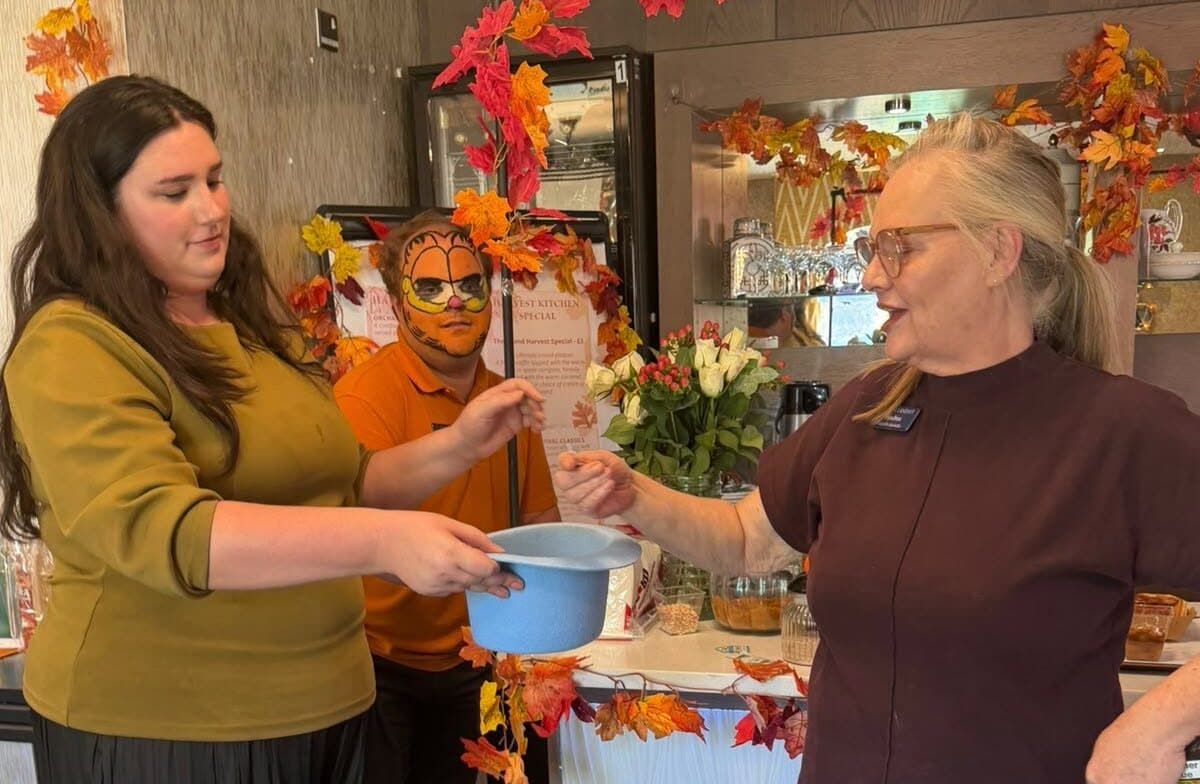 2 ladies holding a hat at the autumn fundraiser